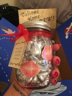 a person holding up a jar filled with candy