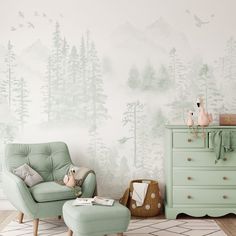 a green chair and ottoman in front of a wall with trees painted on the walls