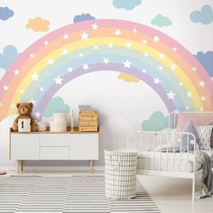 a child's bedroom with a rainbow wall mural