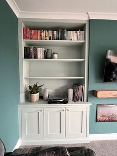 a living room with bookshelves and pictures on the wall