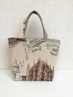 Shoulder bag handmade in Sicily Bucket model with print of the main Italian monuments Milan Cathedral, Bridge with gondola in Venice, Colosseum in Rome. Made of fine GOBELIN fabric that recalls the famous GOBELINS tapestries Internally it is lined and on which I have applied a large pocket Measures: Height 26cm Width 24cm Depth 14cm Handle height 18 cm Unique piece / One of a Kind bag You can find my other articles on https://www.etsy.com/it/shop/GirosSICILIA Beige Fabric Bag For Daily Use, Beige Fabric Bags For Daily Use, Beige Tote Bag With Zipper Pouch, Fabric Bags With Zipper Pouch As Gift, Handmade Pouch Canvas Bag For Daily Use, Handmade Beige Canvas Bag For Daily Use, Fabric Travel Pouch Bag, Handmade Canvas Pouch Bag For Daily Use, Fabric Shoulder Bag Suitable For Gifts