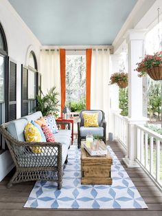 the front porch is decorated in blue and white with lots of furniture on top of it