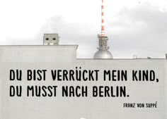 an advertisement on the side of a building with a tv tower in the back ground