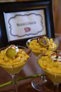 three glasses filled with dessert sitting on top of a table next to a framed photo