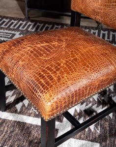 a brown leather chair sitting on top of a rug