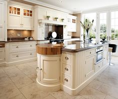 an image of a kitchen setting with white cabinets and counter tops, along with a center island in the middle