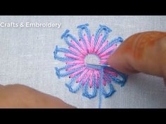 someone is stitching a flower on a piece of fabric