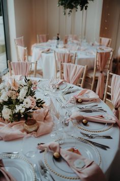 the table is set with pink linens and place settings for an elegant wedding reception