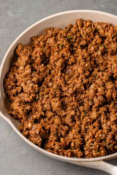 a close up of food in a pan on a table with a spoon next to it