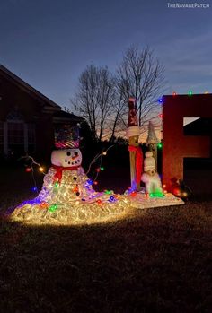 a snowman made out of christmas lights in front of a house