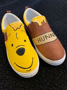 a pair of shoes painted to look like winnie the pooh are sitting on a carpet