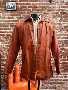 Mens 70s Supple Leather Burnt Sienna Jacket  Sharp men's seventies supple leather burnt sienna jacket. The color is beyond. Completely irresistible. This type of high quality leather from the seventies is so beautiful. Small, sharp collar. Four leather button  front closure. Two leather buttons on each cuff. Two small front pockets. Gold lining. This type of 70s leather jacket is for style, not rain or it will get water marks. No label. 🌻Water marks, marks and scuffs throughout. Wear on the back, especially the right sleeve. Stains on the lining. See photos. Please do not purchase if this bothers you. Measurements:  18" shoulder  38" chest  20.5" pit to pit  30.75" length from high point of shoulder to hem  25" sleeve No returns or exchanges  Feel free to message us with any questions. We Vintage Leather Outerwear For Fall, Retro Brown Leather Outerwear, Vintage Brown Leather Jacket For Fall, Retro Leather Outerwear For Fall, Vintage Distressed Brown Outerwear For Fall, Vintage Brown Retro Single Breasted Outerwear, Retro Brown Leather Jacket For Fall, Vintage Brown Retro Single-breasted Outerwear, Vintage Single-breasted Leather Outerwear