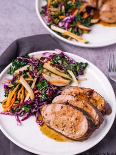 two white plates topped with meat and veggies on top of a purple table cloth