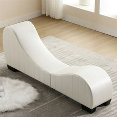 a white chaise lounger sitting on top of a rug