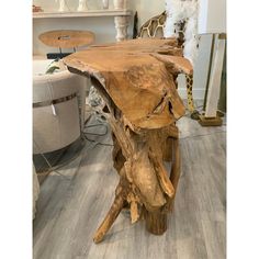 a wooden table made out of logs in a room with other furniture and accessories on the floor