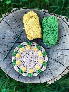 two balls of yarn sitting on top of a tree stump