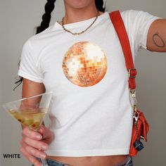 🌟 Embrace your inner Y2K icon with this unique retro disco ball tee! Designed with a watercolor print that gives it a soft, dreamy look, this shirt is perfect for those who love to add a touch of vintage coquette style to their wardrobe. Lightweight and comfy, it's ideal for a casual day out or a funky party night. 🎨🛍️  Looking for a graphic baby tee nostalgic of the 90s? Bring your Y2K outfit dreams to life with our newest collection. This classic baby tee will fit like a well-loved favorite Funky Party, Retro Disco, Vintage Coquette, Coquette Style, Baby Graphic Tees, 90s Baby, Mirror Ball, Shirt Y2k, Y2k Clothing