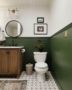 a white toilet sitting in a bathroom next to a wooden cabinet and mirror on the wall