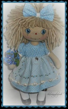 a doll with blonde hair wearing a blue dress and holding a flower in her hand