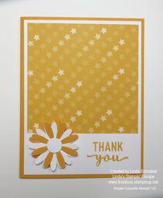 a thank you card with yellow stars and white paper on the bottom, in front of an orange background