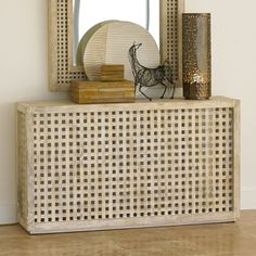 a wooden table topped with a mirror and vase