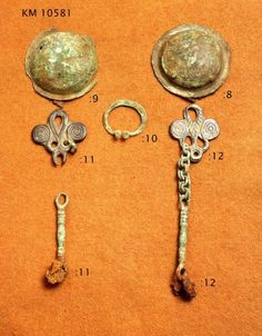 four pieces of ancient jewelry are displayed on a brown surface with numbers in the bottom left corner