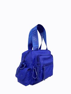 The Block Bag is lined in recycled rPET fabric with matching blue powder-coated hardware, carabiner and faux leather zip pullers. With a short nylon strap and an extra adjustable long nylon strap, this bag provides versatility and can be worn on the arm, or as a cross-body bag. This bag features an internal and external zip pocket, a front two section compartment, and two side compartments to provide added practicality. * rPET fabric is made from recycled post-consumer plastics otherwise destine Zip Puller, Belt Jewelry, Cosmetic Pouch, Waist Bag, The Block, Body Bag, Powder Coated, Electric Blue, Leather Crossbody