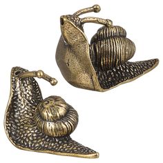 two pieces of metal that are shaped like snails and one has a shell on it