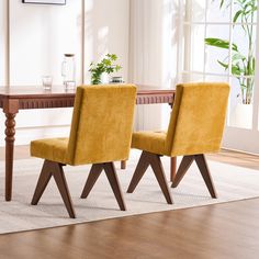 two yellow chairs sitting in front of a wooden table