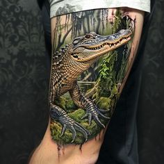 a man's leg with an alligator tattoo on it, and trees in the background