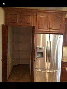 a stainless steel refrigerator freezer sitting inside of a kitchen next to wooden cupboards