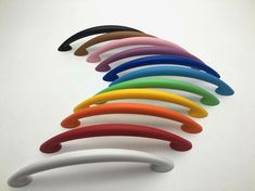 an assortment of different colored handles on a white surface