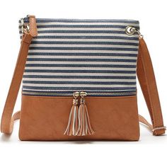 a blue and white striped bag with tassels on the front, two zippered straps