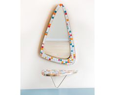 a mirror sitting on top of a wall next to a ironing board