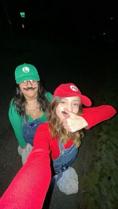 two women with fake mustaches on their faces posing for the camera in front of a dark background