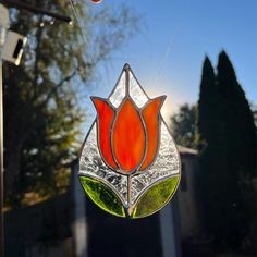 a stained glass sun catcher hanging from a window