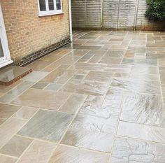 an outdoor patio with stone flooring and brick walls