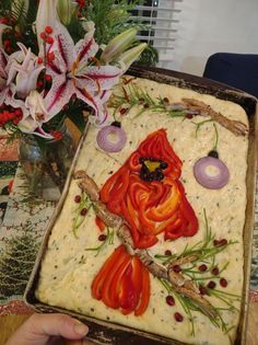 a person holding up a cake decorated with an image of a red bird on it