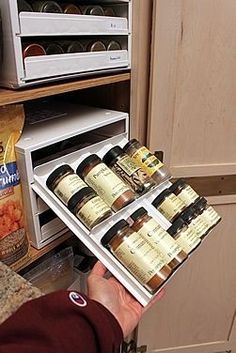 a person is holding an open spice rack