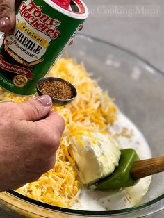 a person dipping cheese on top of food in a bowl