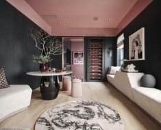 a black and white living room with pink accents on the walls, rugs and tables