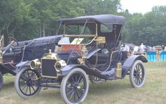 an antique car is parked on the grass