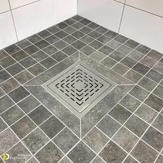 a tiled floor with a drain in the middle