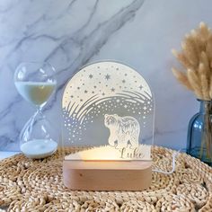 an illuminated bear with stars in the sky on top of a table next to some vases