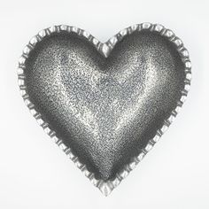 a silver heart shaped object on a white background