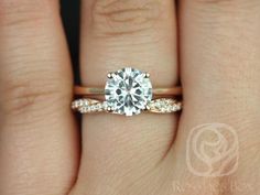 a woman's hand with a diamond ring on top of her finger and the engagement band