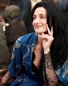 a woman with long black hair sitting down