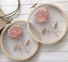 two embroidery hoops with pink flowers on them