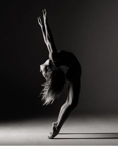 a woman is doing a handstand in the air with her legs spread out