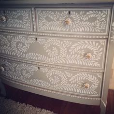 an ornate painted dresser with drawers and knobs